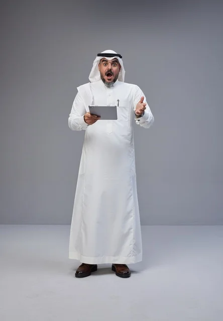 Surprised Saudi Man with Tablet on Grey Background