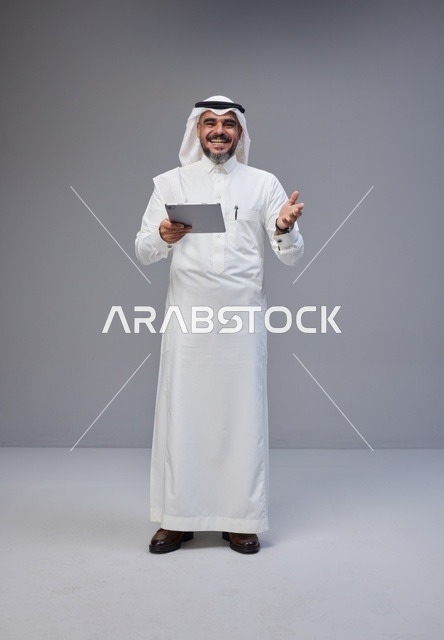 Saudi Man in Traditional Thobe Using Digital Tablet