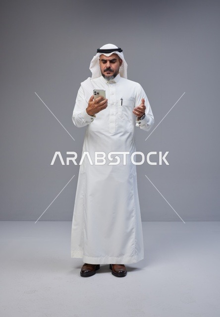 Saudi Man in Traditional Thobe Holding Smartphone
