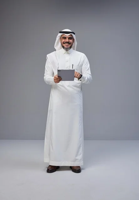 Saudi Man in Traditional Dress Using Tablet in Studio