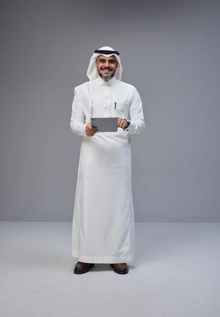 Saudi Man in Traditional Dress Using Tablet