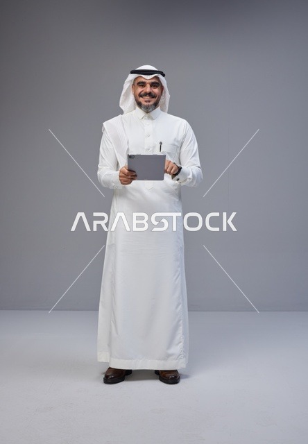 Saudi Man in Traditional Thobe Holding Digital Tablet