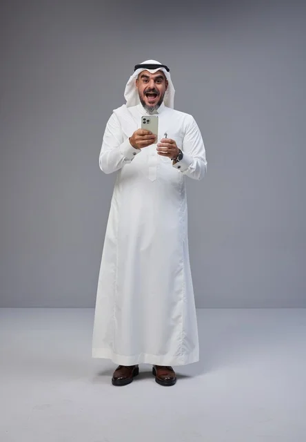 Excited Saudi Man with Smartphone in Studio