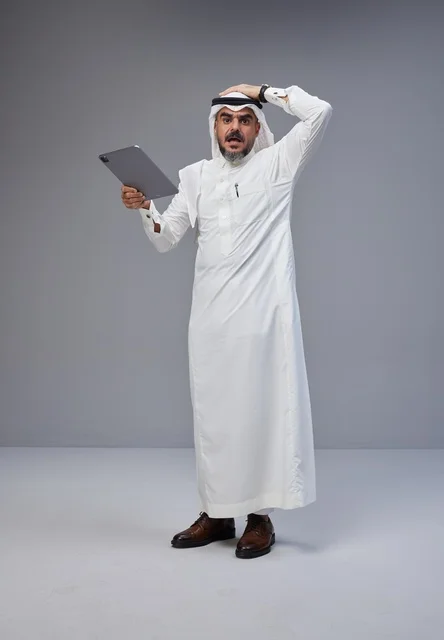 Shocked Saudi Man Holding Tablet on Grey Background