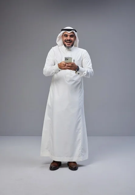 Saudi Man in Traditional Thobe Using Smartphone