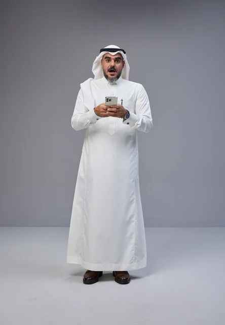 Surprised Saudi Man in Traditional Dress Using Smartphone