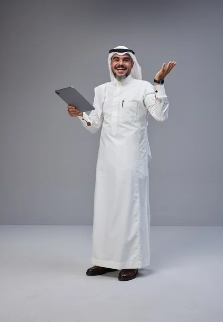 Saudi Man in Traditional Thobe Using Digital Tablet