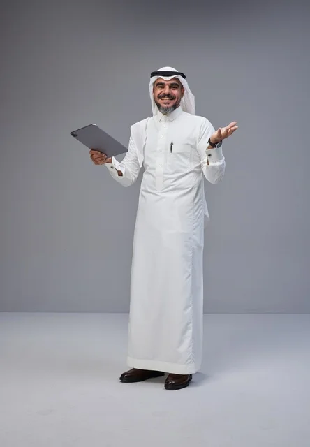 Saudi Man in Traditional Dress Using Tablet in Studio