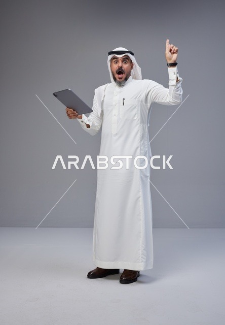 Saudi Arabic Man with Tablet Pointing Upwards in Studio