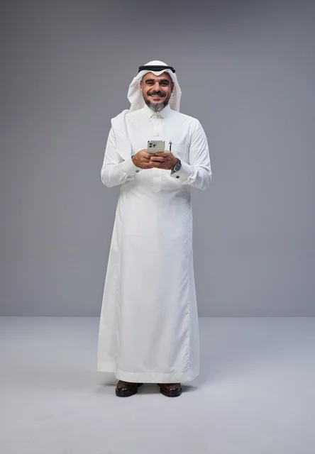 Saudi Man in Traditional Thobe Using Smartphone