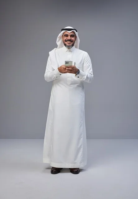 Saudi Man in Traditional Thobe Holding Smartphone