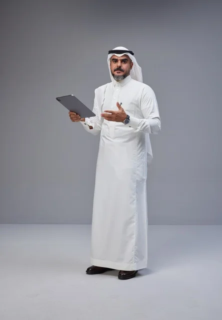 Saudi Man in Traditional Dress with Digital Tablet