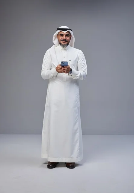 Saudi Man in Traditional Thobe Using Smartphone