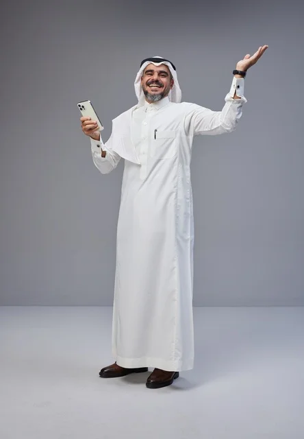 Smiling Saudi Man using Smartphone in Studio Portrait