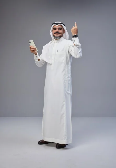 Saudi Man in Traditional Thobe Holding Smartphone
