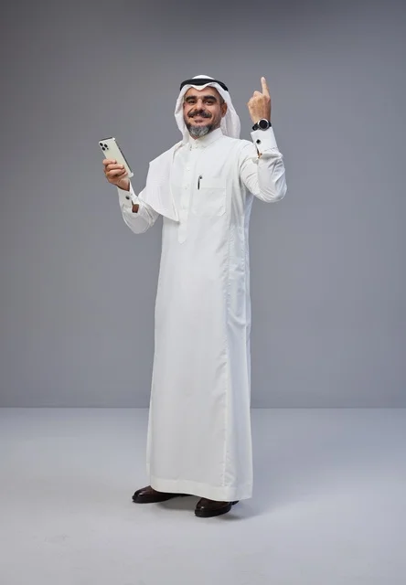 Saudi Man in Thobe with Smartphone Pointing Up