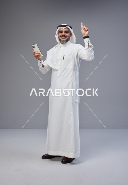 Saudi Man in Traditional Thobe Holding Smartphone
