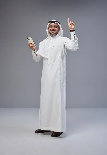 Saudi Man in Traditional Dress Using Smartphone Studio