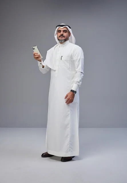 Saudi Man in Traditional Thobe Holding Smartphone