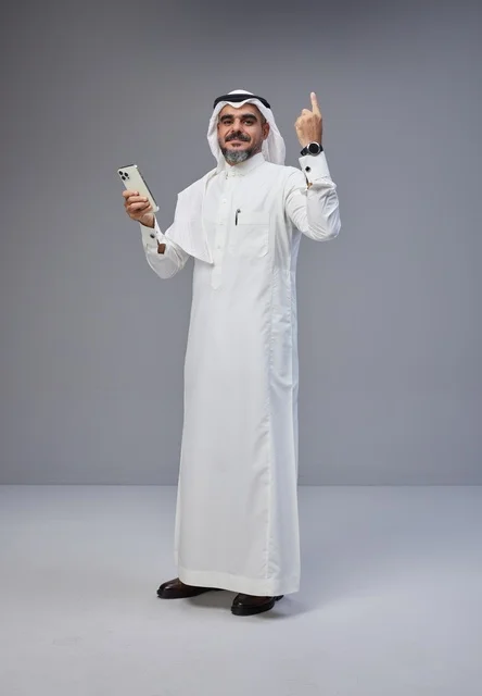 Saudi Man in Traditional Thobe Using Smartphone