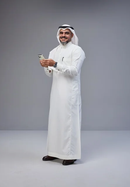 Saudi Man in Traditional Thobe Using Smartphone
