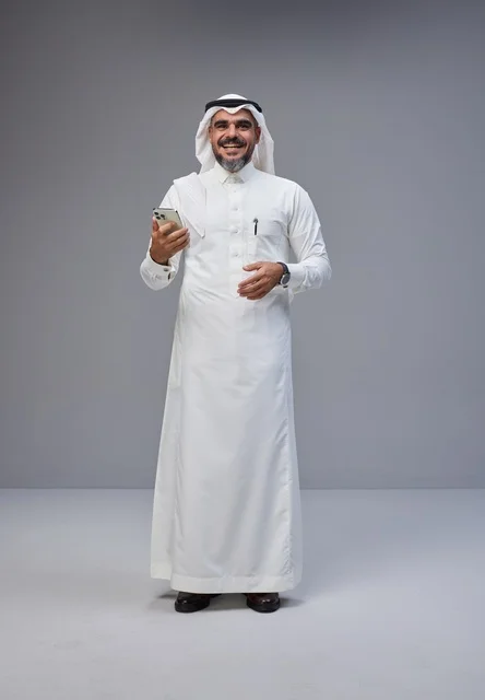 Saudi Man in Traditional Thobe Holding Smartphone