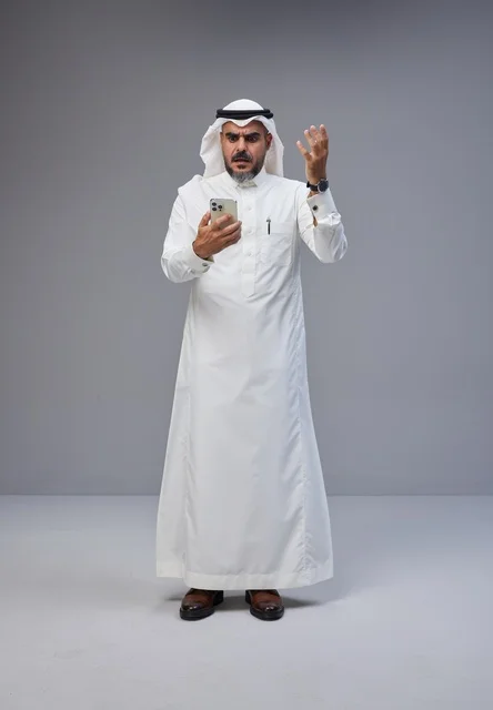 Saudi Man in Traditional Dress Frustrated with Smartphone