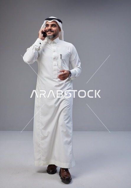 Saudi Man in Traditional Thobe Talking on Mobile Phone
