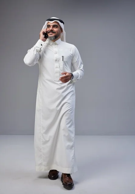 Saudi Man in Traditional Thobe Talking on Mobile Phone