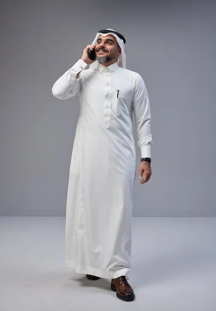 Saudi Man in Traditional Dress Talking on Mobile Phone