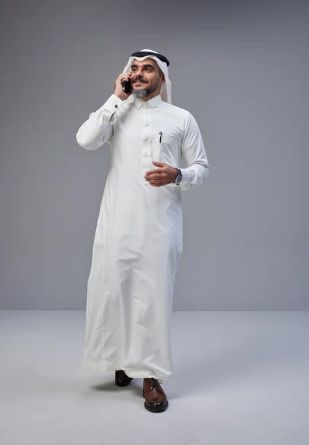 رجل سعودي بالزي التقليدي يتحدث بالهاتف المحمول