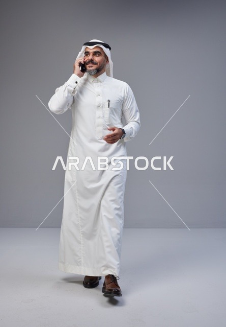 رجل سعودي بالزي التقليدي يتحدث عبر الهاتف