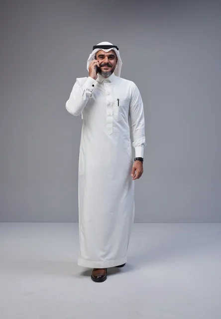 رجل سعودي بالزي التقليدي يتحدث عبر الهاتف الجوال