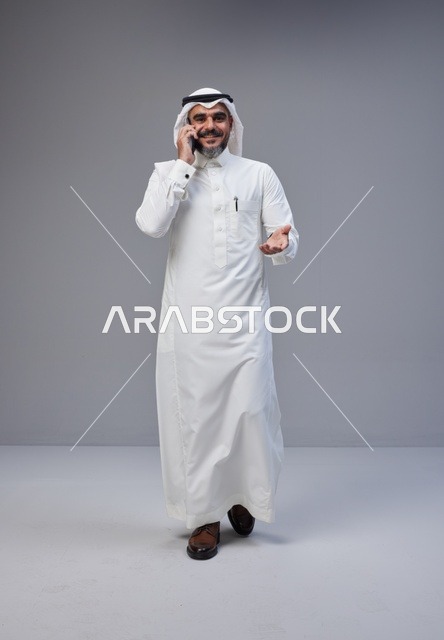 Saudi Man in Traditional Thobe Talking on Phone