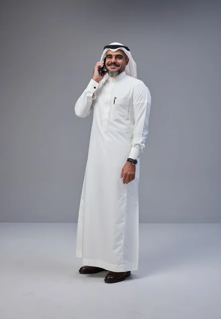 رجل سعودي بالزي التقليدي يتحدث عبر الهاتف المحمول