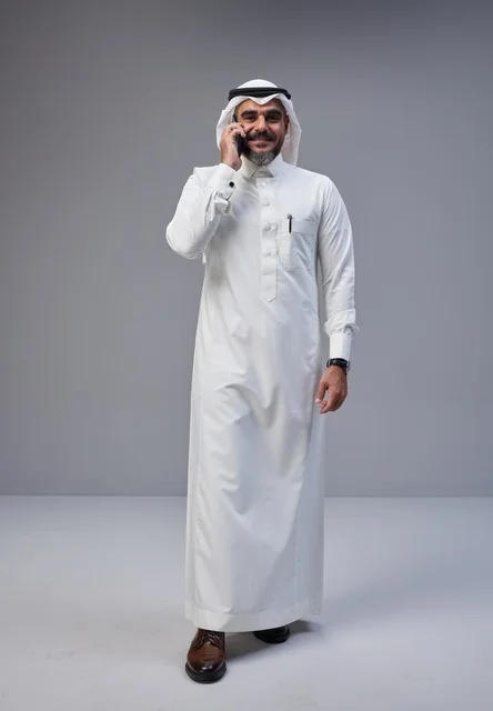 رجل سعودي بالزي التقليدي يتحدث عبر الهاتف الجوال