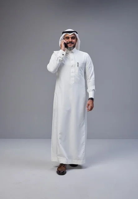 Saudi Man in Traditional Thobe Talking on Phone