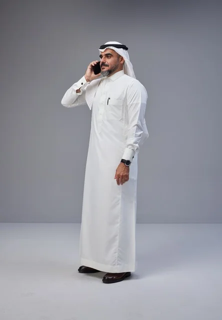 رجل سعودي بالزي التقليدي يتحدث عبر الهاتف المحمول
