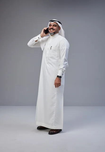 Saudi Man in Traditional Dress Talking on Mobile Phone