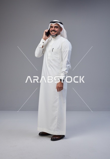 رجل سعودي بالزي التقليدي يتحدث عبر الجوال