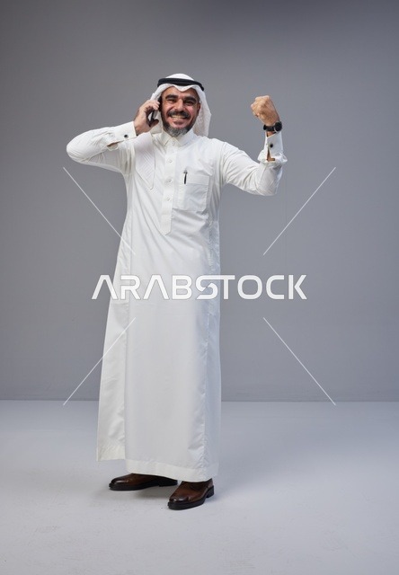 Saudi Man in Traditional Thobe Celebrating on Phone
