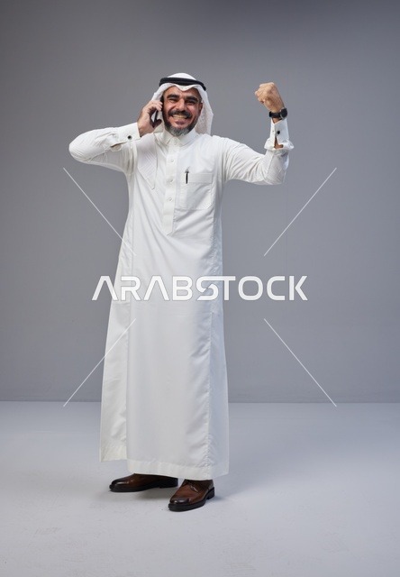 Saudi Man Talking on Smartphone with Victory Gesture