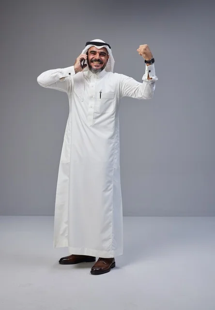 Saudi Man Talking on Smartphone with Victory Gesture