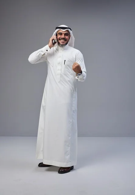 Saudi Man Talking on Smartphone with Success Gesture