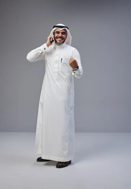 Saudi Man Talking on Phone with Success Gesture