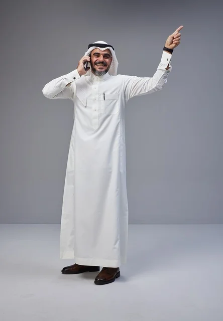 Saudi Man in Thobe Talking on Phone Pointing Upwards