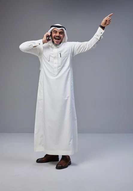 رجل سعودي يتحدث بالهاتف ويشير للأعلى بحماس