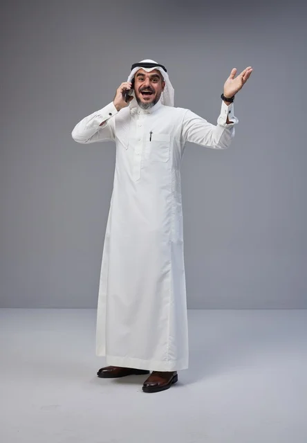 Saudi Man in Traditional Thobe Talking on Phone