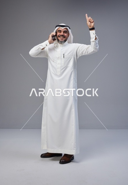 Saudi Man in Traditional Thobe Talking on Phone