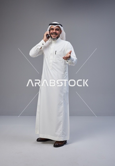 رجل سعودي بالزي التقليدي يتحدث عبر الهاتف الجوال